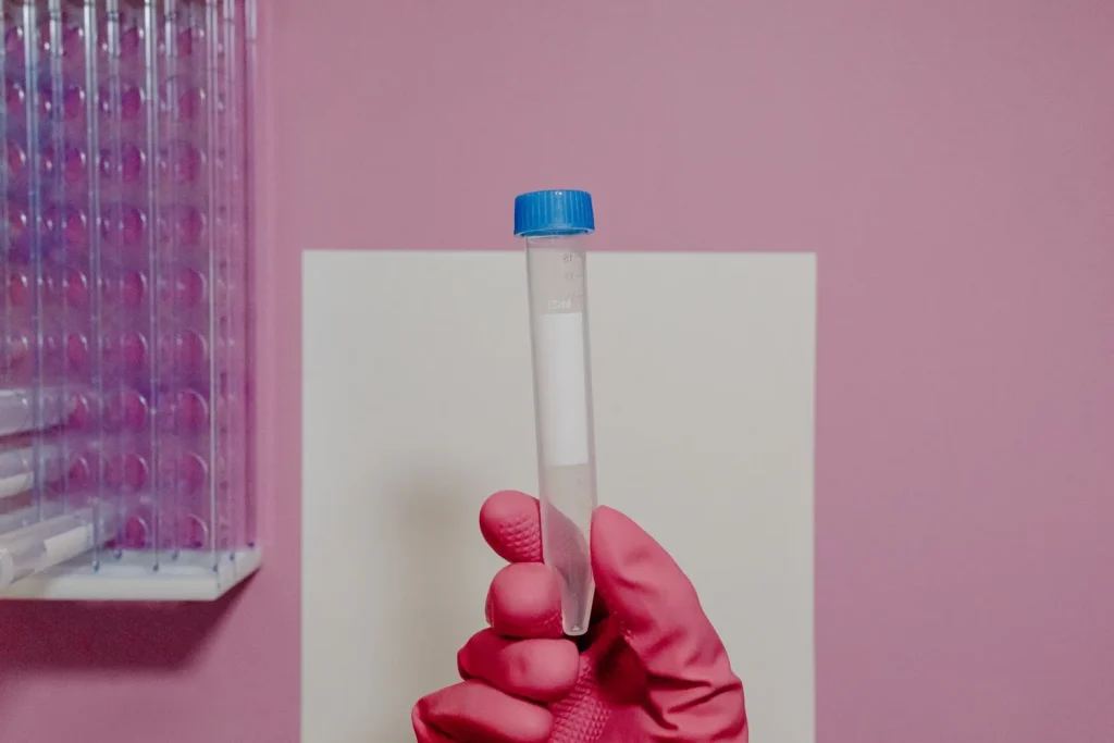 Gloved hand holding a sealed test tube in the laboratory
